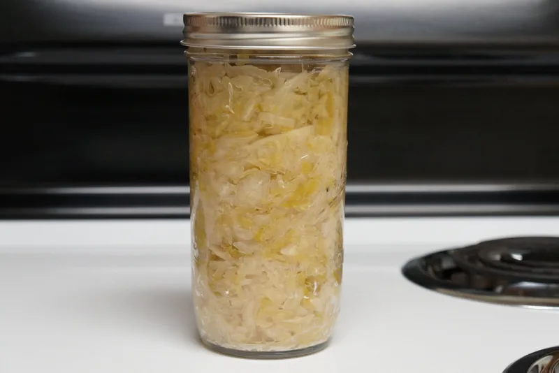 Glass jar of naturally fermented sauerkraut in its own brine