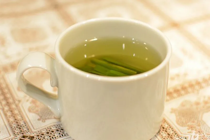 Cană de ceai de lemongrass cu tulpini verzi proaspete de iarbă de lămâie
