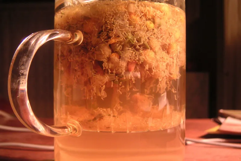 Steaming cup of herbal tea on a bedside table, prepared for a restful night's sleep