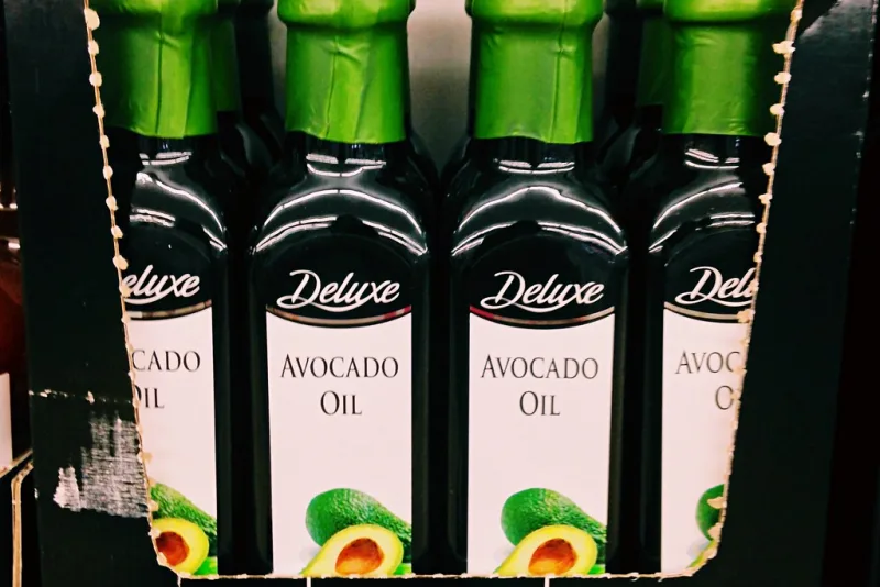 Bottles of greenish-golden avocado oil pressed from the flesh of the avocado fruit