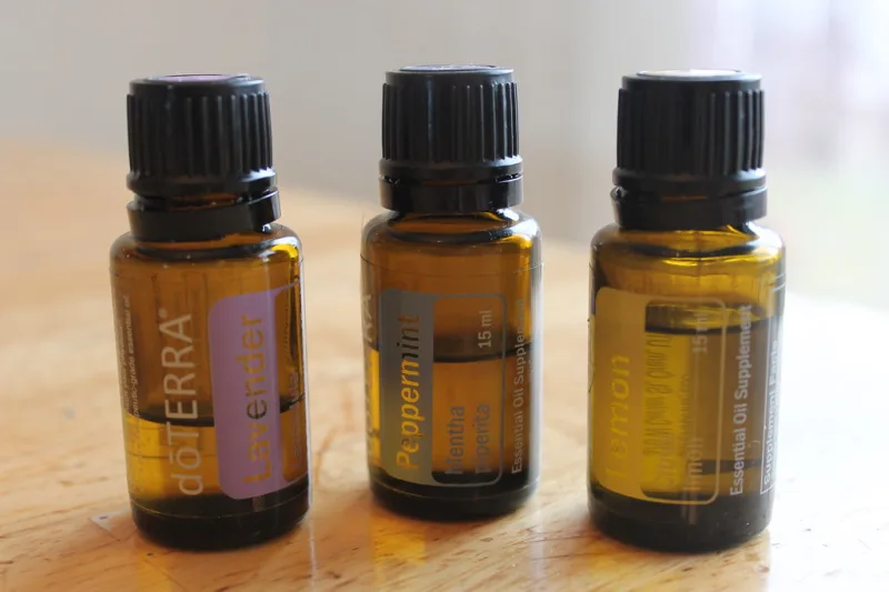 Essential oil bottles, including lemon essential oil, on a wooden table